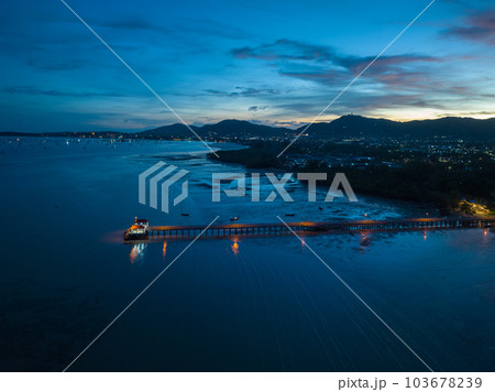 aerial photography cloud above Palai pier at beautiful sunset..Palai pier is next to Chalong pier..fishing boats parking on the beach..colorful cloud above the mountain range background.. 103678239