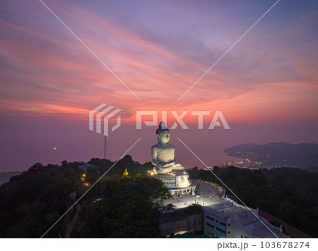 aerial view Phuket big Buddha in beautiful sunset. the sun shines through the clouds impact on ocean surface The beauty of the statue fits perfectly with the charming nature. cloud scape background. 103678274