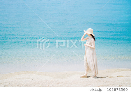 海辺を歩く若い女性 103678560