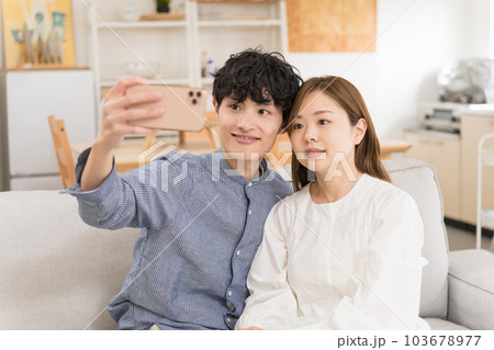 新居でスマホで自撮りするカップル 103678977