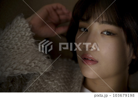 顔に光があたる若い女性のポートレート 103679198