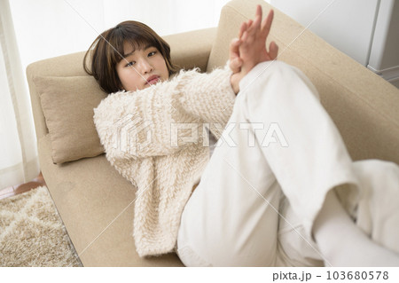 ソファに寝そべる若い女性 103680578