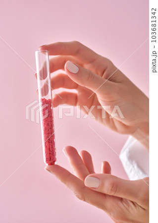 The girl is holding a test tube with red hearts. The girl is holding a test tube with red hearts. 103681342