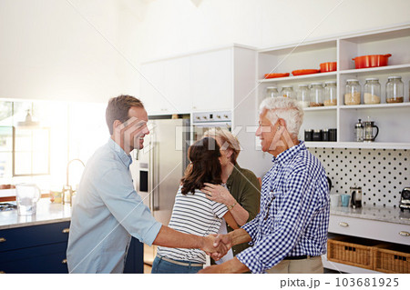 Its so great to see you again. a loving family greeting each other with hugs in the kitchen at home. 103681925