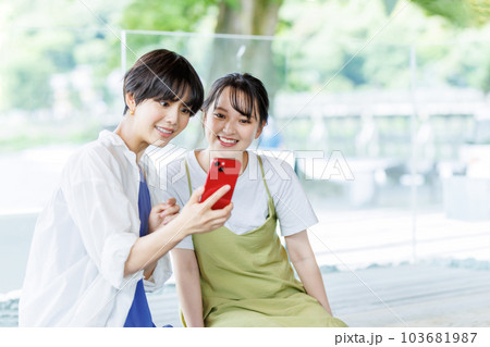 女子旅で足湯に入ってスマホを見る女性 103681987