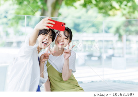 女子旅で足湯に入って自撮りする女性 103681997