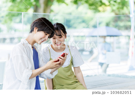女子旅で足湯に入ってスマホを見る女性 103682051