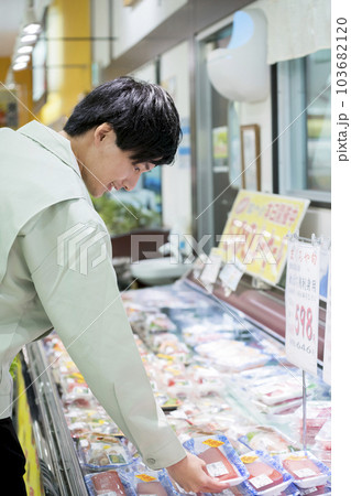 スーパーでまぐろのさくを手に取る作業員男性 103682120