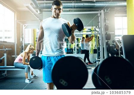 Dont let anyone take away your determination. a young man working out alone in the gym. 103685379