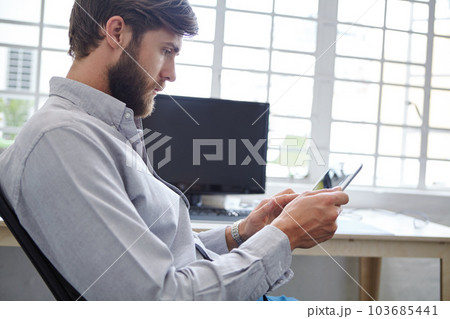 Technology has all the answers. a young designer using his digital tablet. Technology has all the answers. a young designer using his digital tablet. 103685441