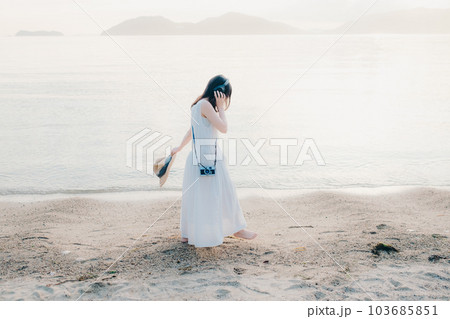 ヘッドフォンをして海を眺める女性 ヘッドフォンをして海を眺める女性 103685851