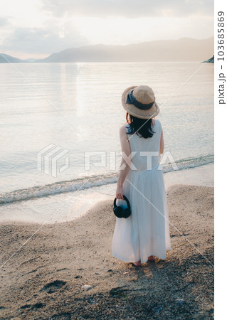 ヘッドフォンをして海を眺める女性 103685869
