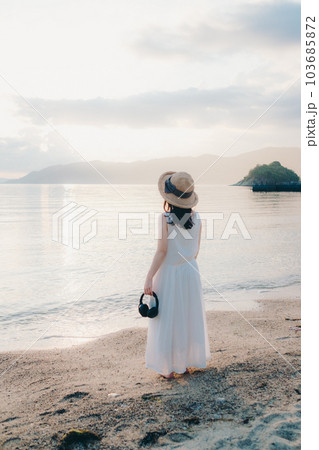 ヘッドフォンをして海を眺める女性 103685872