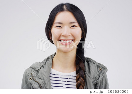 Woman, portrait and asian with smile with studio white background is joyful with confidence. Female smiling, face and happiness with empowerment in China for excited youth with casual outfit. 103686003