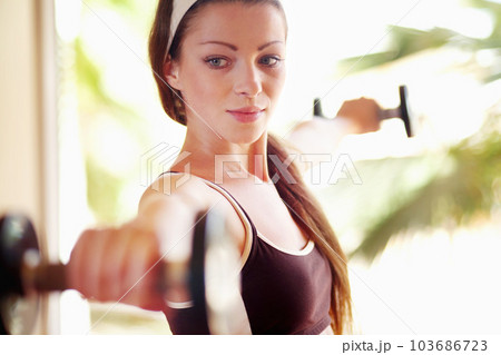 Sports, workout and woman with dumbbells for exercise, training or fitness. Athlete, bodybuilder and female person weight lifting for strong muscle, serious power or health, wellness or energy in gym 103686723