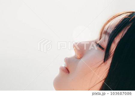 夕焼けに佇む女性 103687086