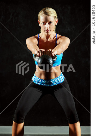 Woman in portrait, kettlebell and weightlifting with fitness, bodybuilder and workout in gym with active person. Exercise, focus and serious female athlete with determination and muscle training Woman in portrait, kettlebell and weightlifting with fitness, bodybuilder and workout in gym with active person. Exercise, focus and serious female athlete with determination and muscle training 103688455