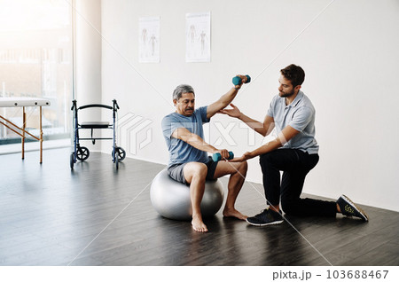 Dumbbells, physiotherapy and balance with doctor and old man for rehabilitation, training and stretching. Healthcare, wellness and healing with patient and expert for consulting, muscle and exercise Dumbbells, physiotherapy and balance with doctor and old man for rehabilitation, training and stretching. Healthcare, wellness and healing with patient and expert for consulting, muscle and exercise 103688467