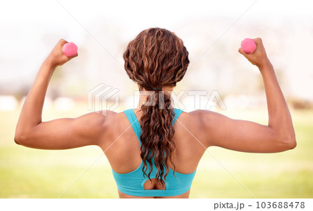 Fitness, park and woman with dumbbell for exercise, body builder training and workout. Sport, weightlifting and back of female athlete with strong muscle for wellness, healthy lifestyle and wellbeing 103688478