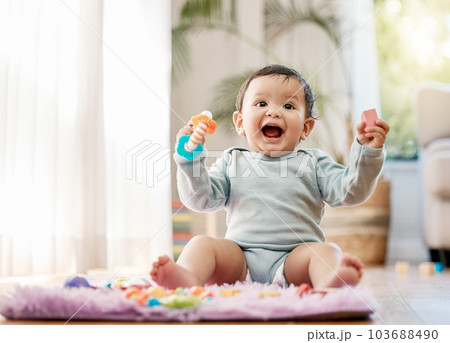 Portrait, smile and happy baby with toys on floor for fun, playing and game at home. Face, excited and toddler boy with creative building blocks for child development, learning or play in living room Portrait, smile and happy baby with toys on floor for fun, playing and game at home. Face, excited and toddler boy with creative building blocks for child development, learning or play in living room 103688490