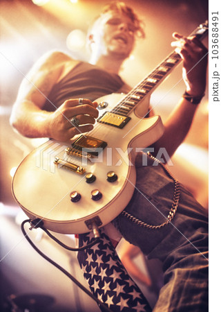 Guitar, man and stage for rock concert, performance and singing at party, event and celebration in night. Male musician, artist or rockstar with instrument at music festival for art, sound and career Guitar, man and stage for rock concert, performance and singing at party, event and celebration in night. Male musician, artist or rockstar with instrument at music festival for art, sound and career 103688491