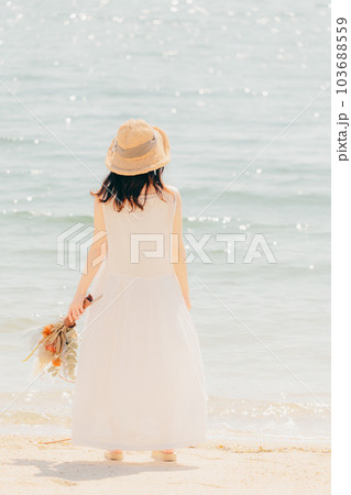 海辺でドライフラワーを持って佇む女性 海辺でドライフラワーを持って佇む女性 103688559
