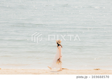 海辺でドライフラワーを持って佇む女性 103688570