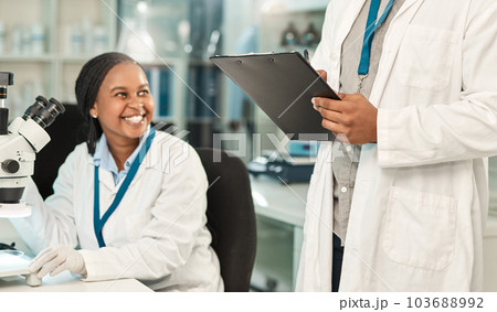 Getting all their lab work done. two scientists working together in a lab. 103688992
