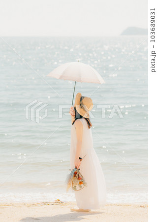 日傘をさしてドライフラワーを持つ女性 103689031
