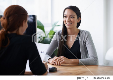Interview, hiring and business women in office in conversation, talking and planning at desk. Communication, partnership and female workers with cv or resume for meeting, recruitment and consulting 103689330