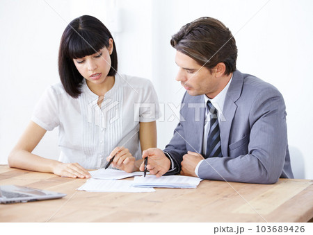 Business people with documents in meeting, team and analysis in office conference room with collaboration. Data analyst employees working together, man and woman with teamwork and corporate paperwork 103689426