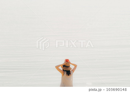 浜辺でりんごを持った女性 103690148