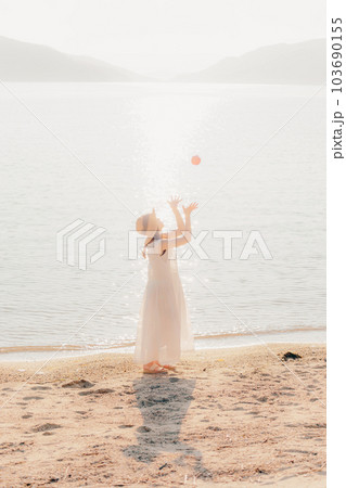 浜辺でりんごを持った女性 103690155
