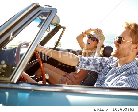 Car road trip, travel and happy couple laughing on holiday bond adventure, transportation journey or fun summer vacation. Love flare, convertible vehicle and driver driving on Canada countryside tour 103690363