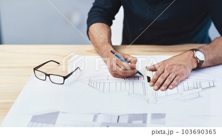 The only way to do it is through creative thinking. an unrecognizable male architect working on a design. 103690365