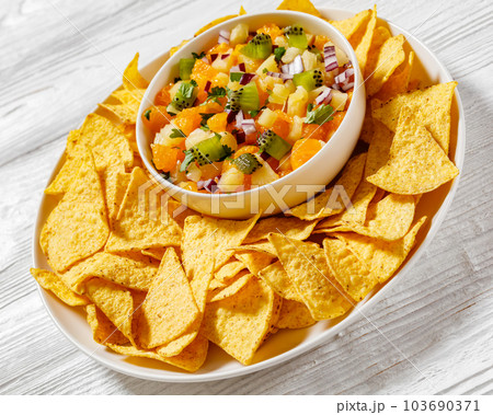 summer fruit salsa with tortilla chips on plate summer fruit salsa with tortilla chips on plate 103690371
