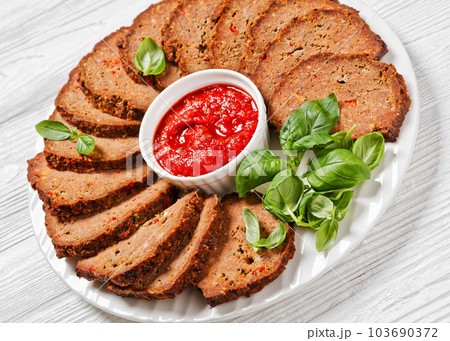 italian meatloaf cut in slices on white plate italian meatloaf cut in slices on white plate 103690372