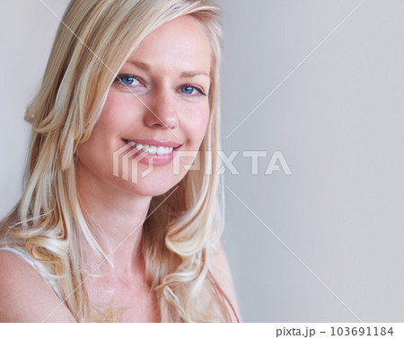 Natural beauty. A gorgeous blonde woman smiling while isolated on a grey background. Natural beauty. A gorgeous blonde woman smiling while isolated on a grey background. 103691184