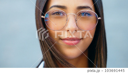 Fashionable student watching, gazing with trendy optometry vision glasses. Detail closeup portrait of funky, cool and friendly woman looking forward in city and wearing optician prescription eyewear 103691445