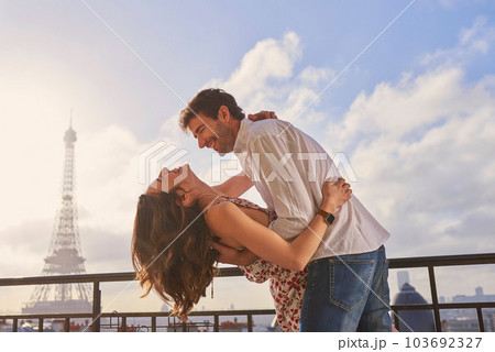 Love, Paris and couple together for a kiss, romantic time or balcony of apartment, hotel with Eiffel Tower in background. Partner, woman and man in France for vacation, travel or honeymoon holiday Love, Paris and couple together for a kiss, romantic time or balcony of apartment, hotel with Eiffel Tower in background. Partner, woman and man in France for vacation, travel or honeymoon holiday 103692327