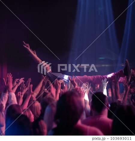 Crowd surf, people at music festival or rock concert, neon lights and energy at live show event. Support, fun and group of excited fans in arena at band performance and person on hands of audience. Crowd surf, people at music festival or rock concert, neon lights and energy at live show event. Support, fun and group of excited fans in arena at band performance and person on hands of audience. 103693011