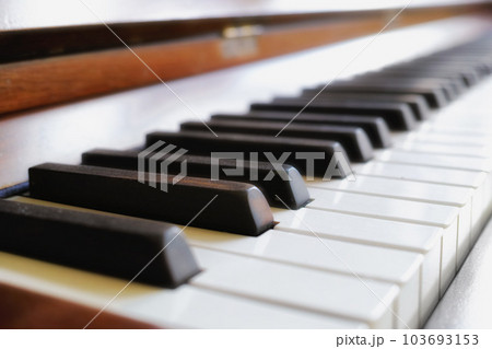 Closeup of classic wooden piano keys on display at a musical art gallery. A vintage keyboard on used to compose classical music or songs. Detail of an old and antique instrument Closeup of classic wooden piano keys on display at a musical art gallery. A vintage keyboard on used to compose classical music or songs. Detail of an old and antique instrument 103693153