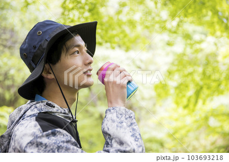 森の中で飲み物を飲む若い男性 アウトドアイメージ 森の中で飲み物を飲む若い男性 アウトドアイメージ 103693218