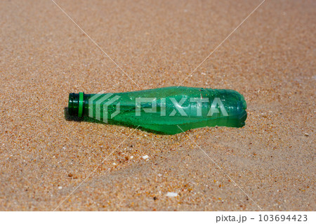 Green plastic bottle on the beach Green plastic bottle on the beach 103694423