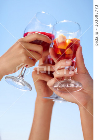 Hands, cocktail toast and friends outdoor for celebration of friendship together. Alcohol, glass and group cheers to celebrate at summer party, event or social gathering for drinking in low angle. 103695773
