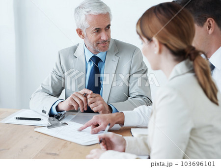 The weekly board room meeting has started. a group of colleagues having a meeting in the boardroom. The weekly board room meeting has started. a group of colleagues having a meeting in the boardroom. 103696101
