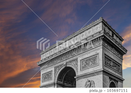 Arc de Triomphe (against the background of sky with clouds), Paris, France. The walls of the arch are engraved with the names of 128 battles and names of 660 French military leaders (in French) 103697151