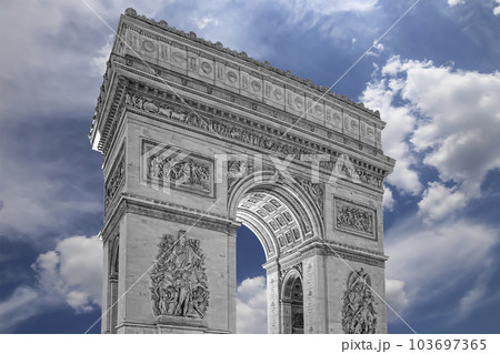 Arc de Triomphe (against the background of sky with clouds), Paris, France. The walls of the arch are engraved with the names of 128 battles and names of 660 French military leaders (in French) 103697365