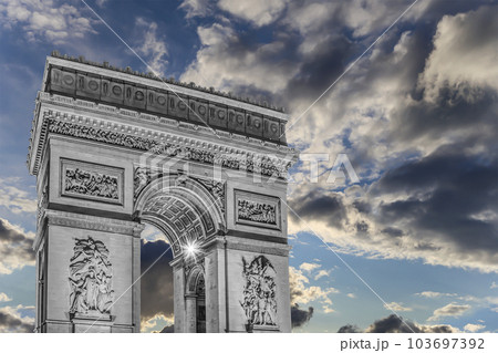 Arc de Triomphe (against the background of sky with clouds), Paris, France. The walls of the arch are engraved with the names of 128 battles and names of 660 French military leaders (in French) 103697392
