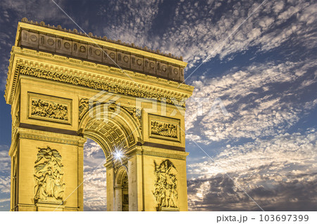 Arc de Triomphe (against the background of sky with clouds), Paris, France. The walls of the arch are engraved with the names of 128 battles and names of 660 French military leaders (in French) 103697399